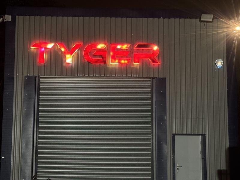 Illuminated TYGER sign on the Tyger Security unit at night